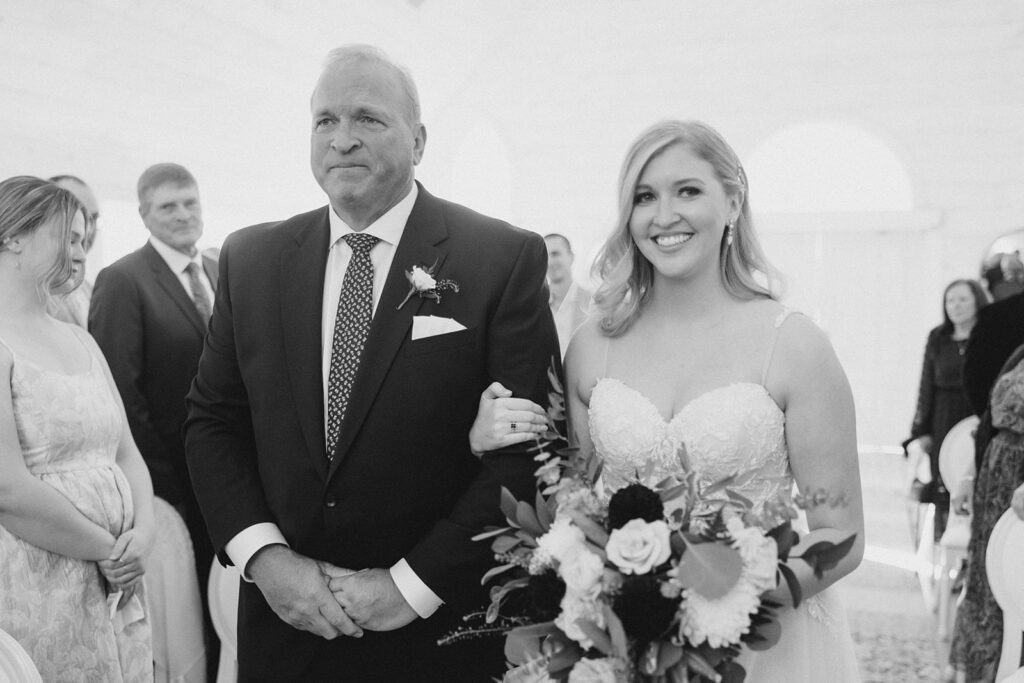 bride and dad walking down the aisle together at Stonefields Estate wedding photographed by Ottawa Wedding Photographer Brittany Navin Photography