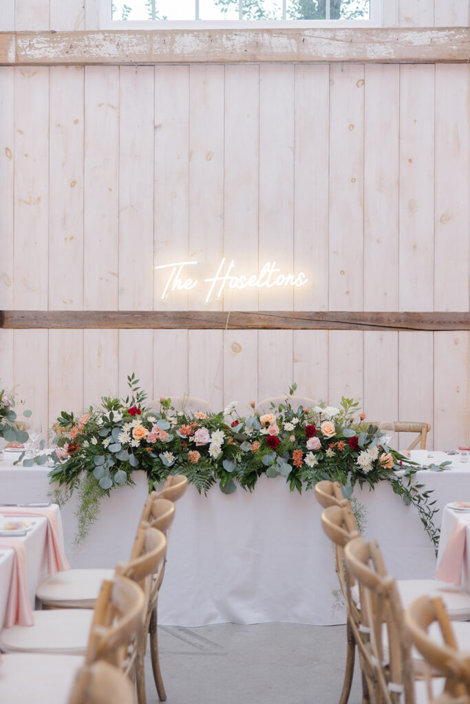 custom neon sign and gorgeous florals for the sweetheart table at Stonefields Estate wedding photographed by Ottawa Wedding Photographer Brittany Navin Photography