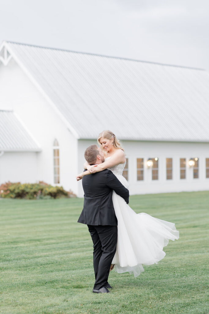 groom lifts bride up like in a fairytale at Stonefields Estate wedding photographed by Ottawa Wedding Photographer Brittany Navin Photography