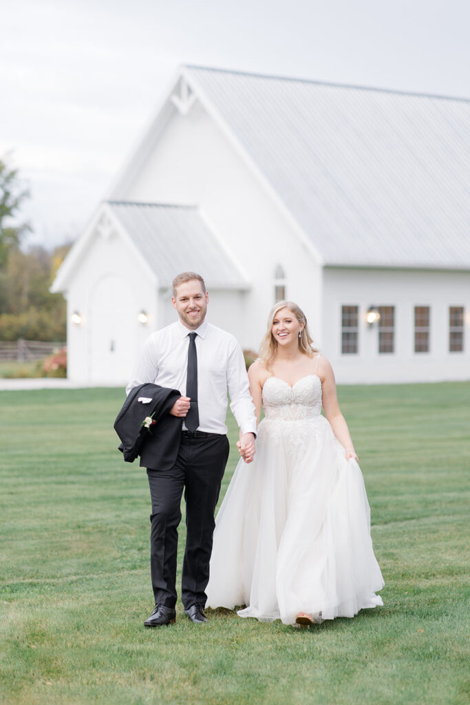 bride and groom walking towards camera and laughing at Stonefields Estate wedding photographed by Ottawa Wedding Photographer Brittany Navin Photography