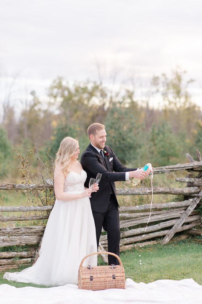 bride and groom pop champagen during their cocktail hour at Stonefields Estate wedding photographed by Ottawa Wedding Photographer Brittany Navin Photography