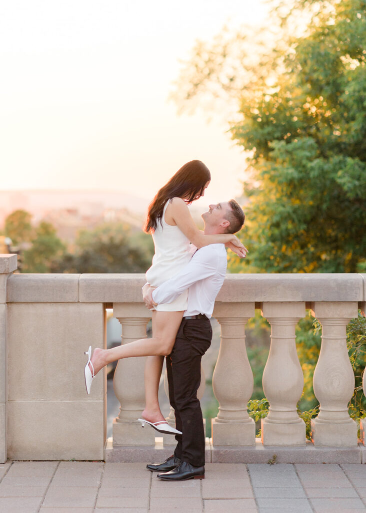 Couple smiling at each other during their Château Laurier engagement photos, wearing modern, classic white and black outfits.