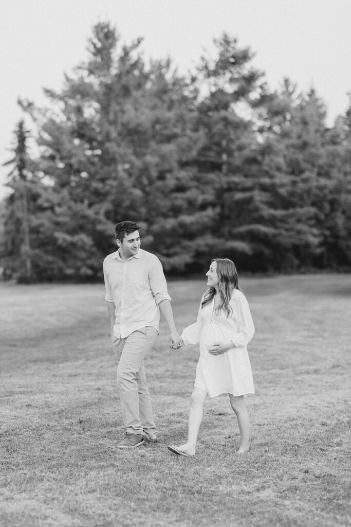 couple walking holding hands at dominion arboretum maternity session in Ottawa photographed by Brittany Navin