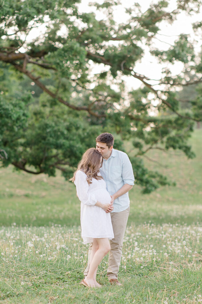 couple holding baby bump at dominion arboretum maternity session in Ottawa photographed by Brittany Navin