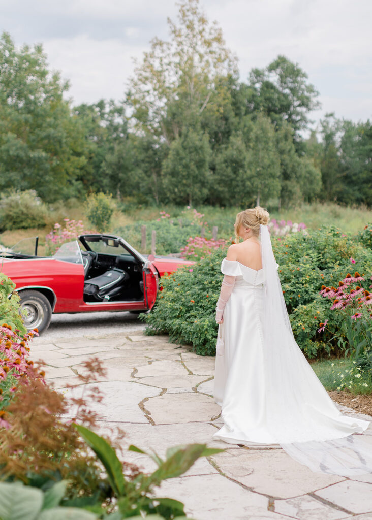bride walking to the Chevelle car to head to her first look at Le Peaches and Cream Wedding photographed by Ottawa wedding photographer, Brittany Navin