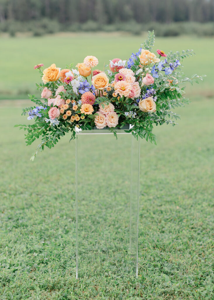 Ceremony set up in the country with peach, blush, and blue florals at Le Peaches and Cream Wedding photographed by Ottawa wedding photographer, Brittany Navin